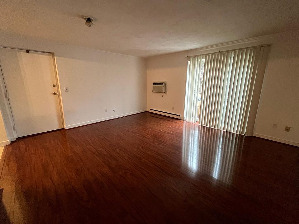 Living room area, with slider to the balcony, wall unit A/C.
