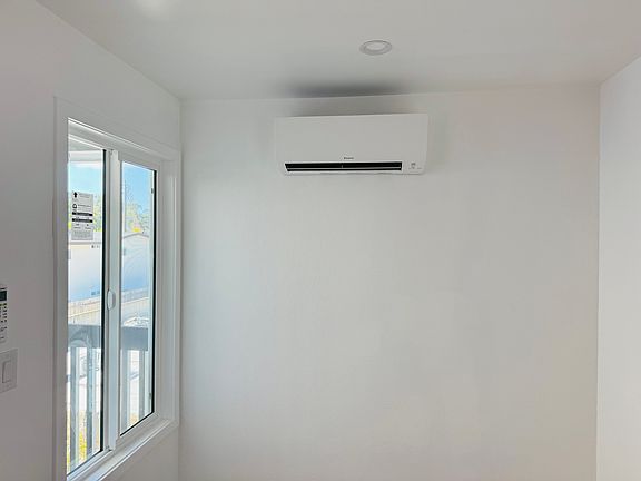 Dining room area filled with natrual light and in wall AC/heating unit.
