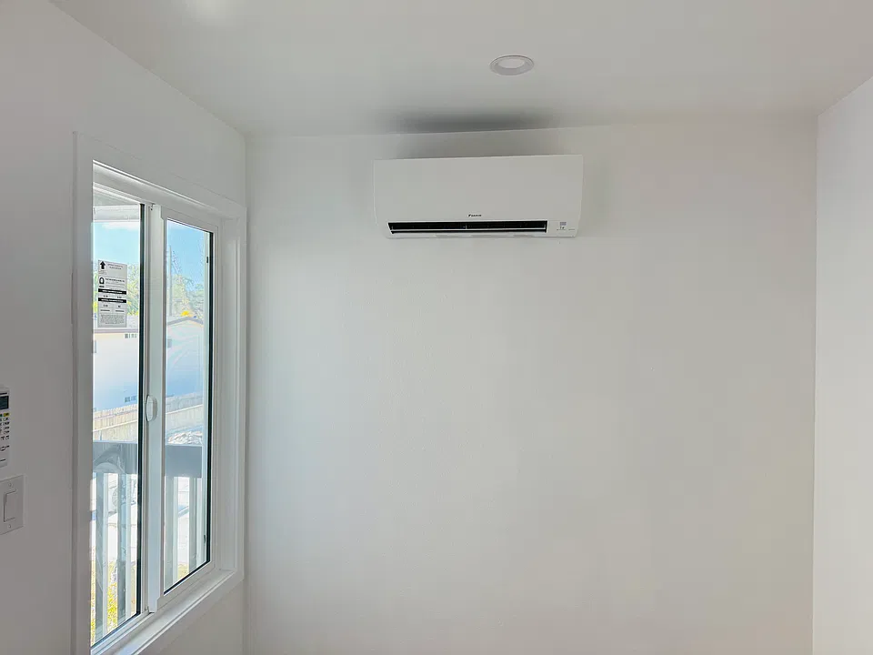 Dining room area filled with natrual light and in wall AC/heating unit.