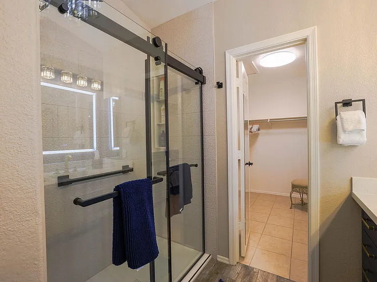 Master suite bath with rain head shower, hand held shower, safety rails, 2 sinks with LED mirrors, 10x magnifying mirror, 2 medicine cabinets, blow dryer, towels for 2
