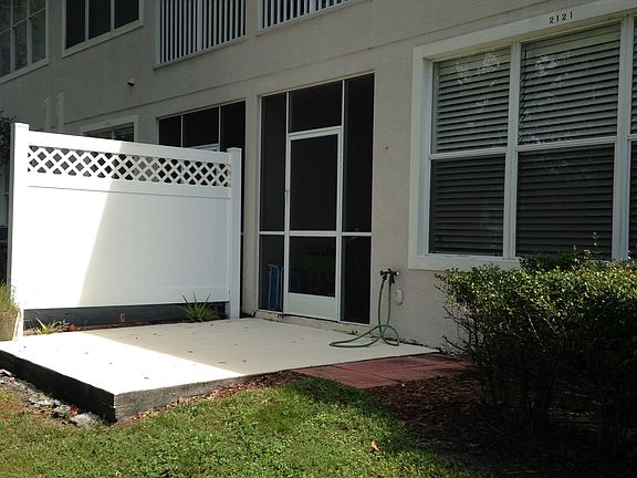 Back slab patio with privacy fence and leads into screened p