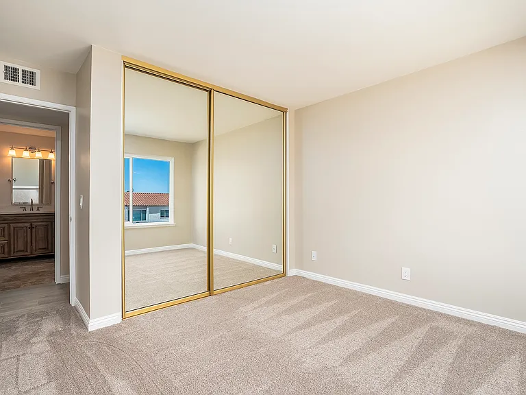 Sliding floor to ceiling mirror doors cover the full size closet in the second bedroom.