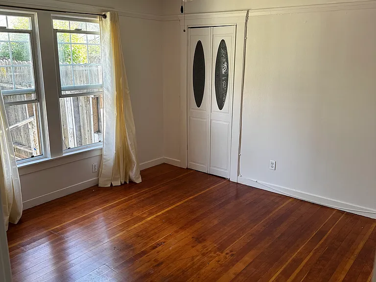 Bedroom with window to the back yard and a closet with bifolding doors