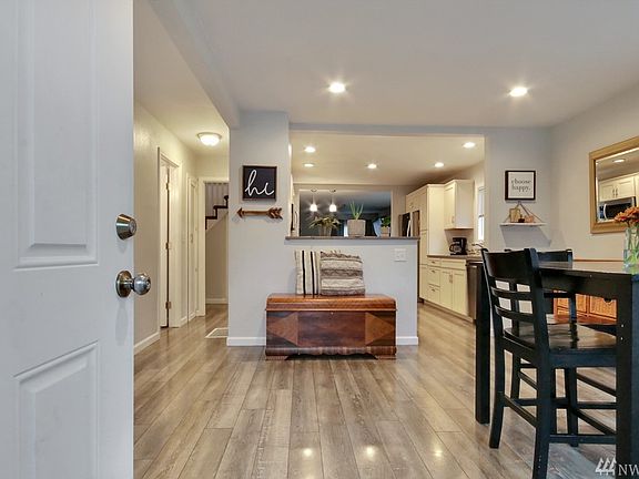 Entry to home shows spacious open concept dining room, moving into kitchen which flows into family room. To the left behind the front door, not in the photo, is the living room. Down hallway is half guest bath, laundry, master bedroom with 3/4 bath. Home boasts of indirect lighting and easy clean vinyl floors. Very well planned, tasteful and functional remodel!