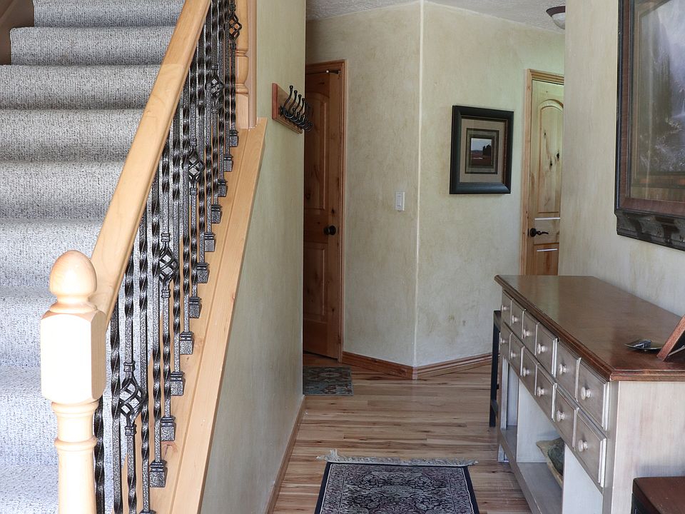 Standing at the front door. 
Main Floor-Kit/Liv/Din/1Primary ensuite\ 1 powder room/ Interior garage door.
Upstairs-Reading nook, Master ensuite, Queen room, room with 2 single beds, full bathroom.