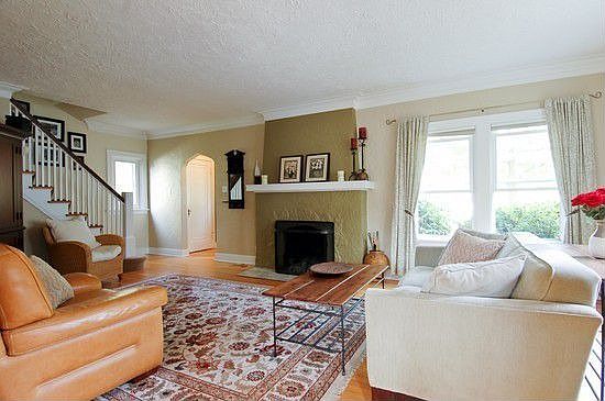 Spacious living room with beautiful crown molding and wood burning fireplace