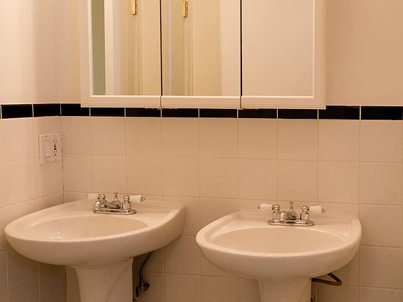 Lower level bathroom with dual pedestal sinks