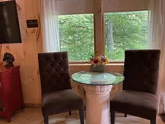 Dresser and 50 inch TV on the left. Table and chairs for eating, working and views of the barns and pastures.
