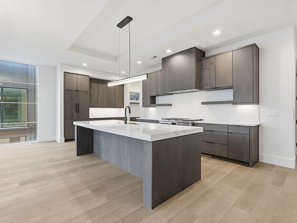 Stunning kitchen with oversized island waterfall island, custom cabinetry, and high-end modern finishes