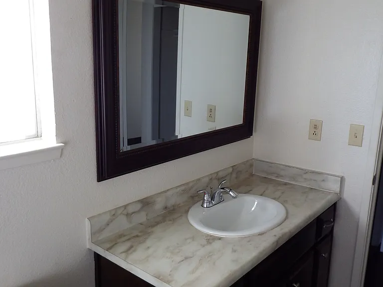 Modern vanity, framed mirror with updated lighting and chrome details