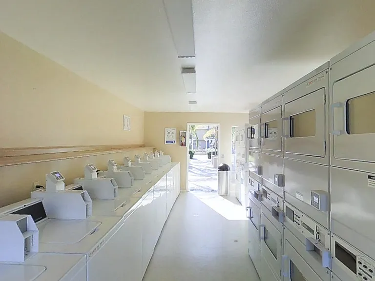 Laundry room view from back toward door with all machines in view