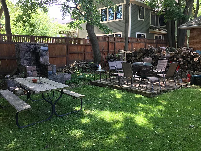 Back yard with class topped picnic table. Fit pit area with seating for 10
