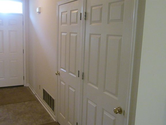 Hallway with coat closet and pantry