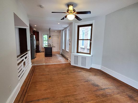 Open-concept dining room with ceiling fan & custom railing.