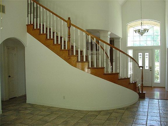 Gorgeous winding staircase between the foyer & living room.