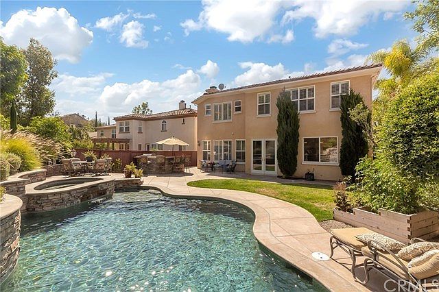 Waterfall pool and spa featuring a built in BBQ and island for entertaining