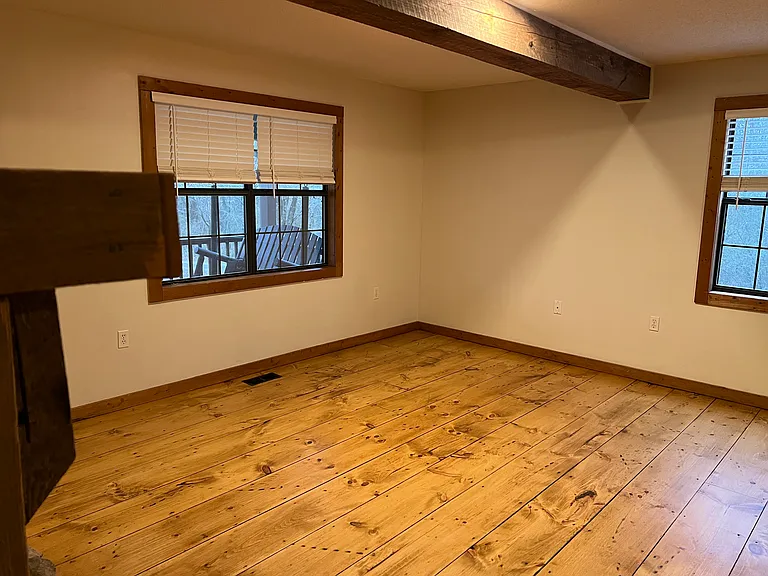 Living area with open exposed beams and lots of natural light.
