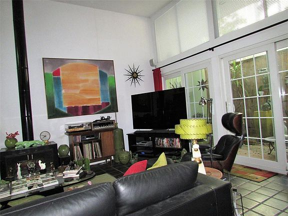 The wall of glass acts as an interior conservatory wall on the shade garden. Perfect for afternoon reading and entertaining, Pri