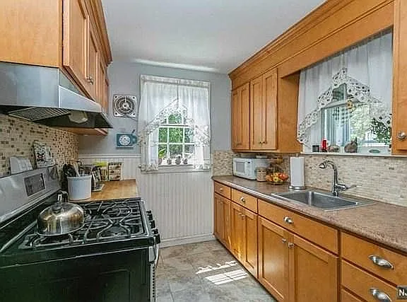 Galley kitchen. Window overlooks fenced in area.