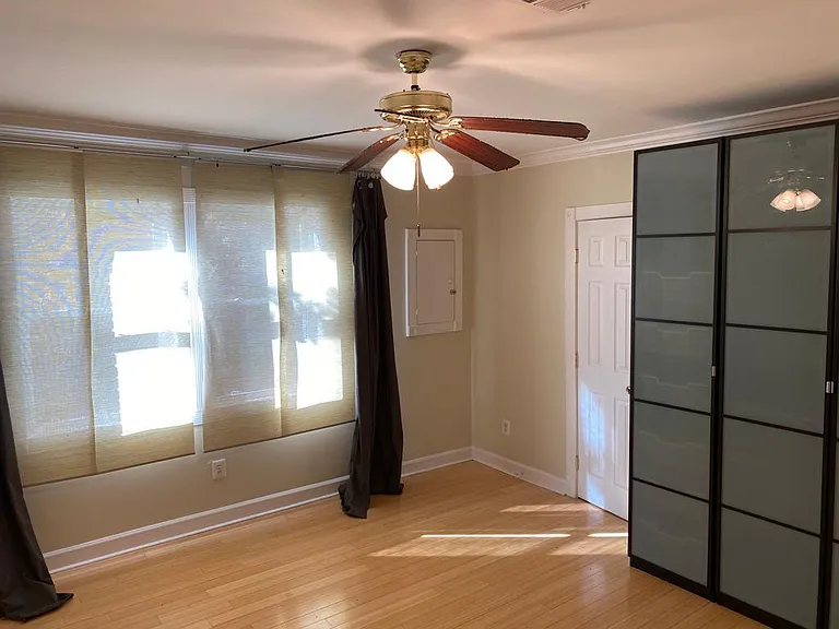 bedroom with street view. White door is the closet, and an additional wardrobe is next to it.