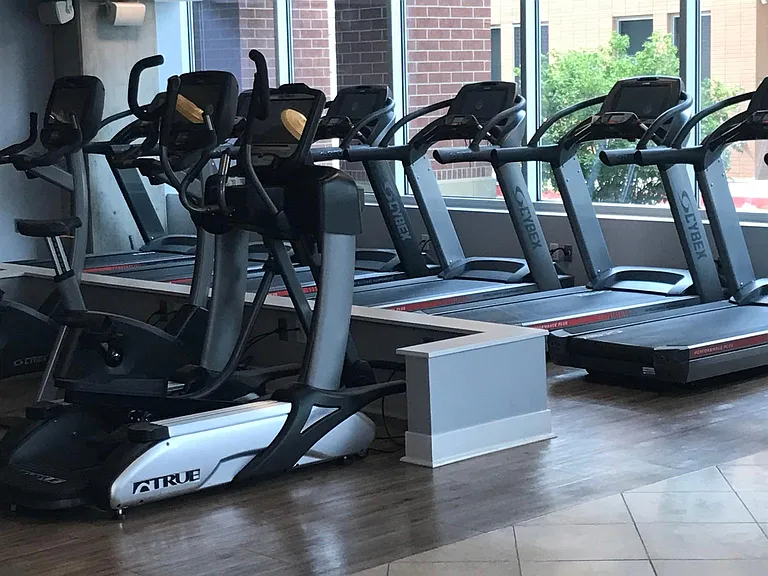 Fitness club membership included with rent. Club features cardio room, weight room, and classes.