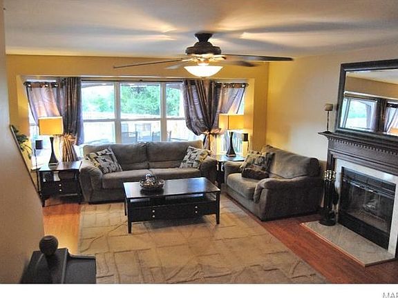 living room with laminate wood flooring and woodburning FP