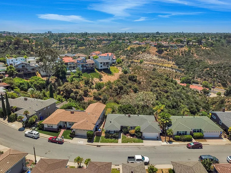 Aerial photo of front of property, with view of large, lush canyon behind the house