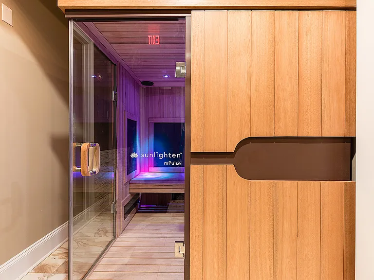 Luxurious community sauna with wood paneling and soft ambient lighting for a relaxing experience.