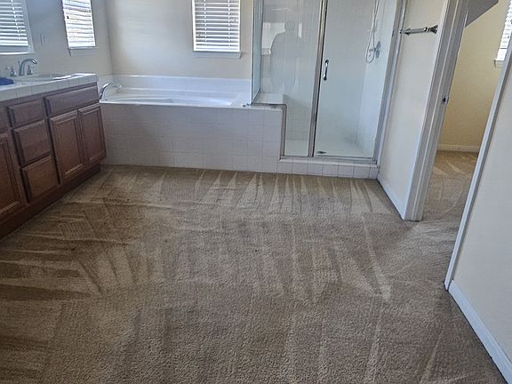 Master bathroom with tub and walk-in closet
