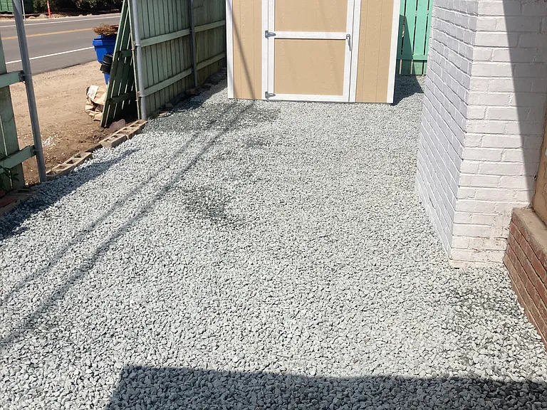 The new lockable storage shed and gravel hardscaping is recently installed. The front porch is the where the photo was taken from. The fence was installed after the gravel was added