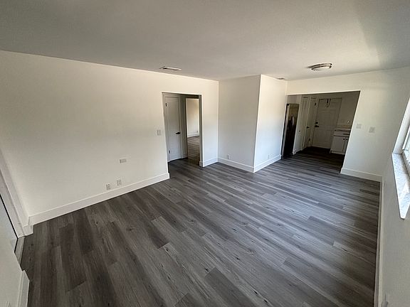 Living room/dining room. Kitchen and back door to patio on right. Front door on the far left.