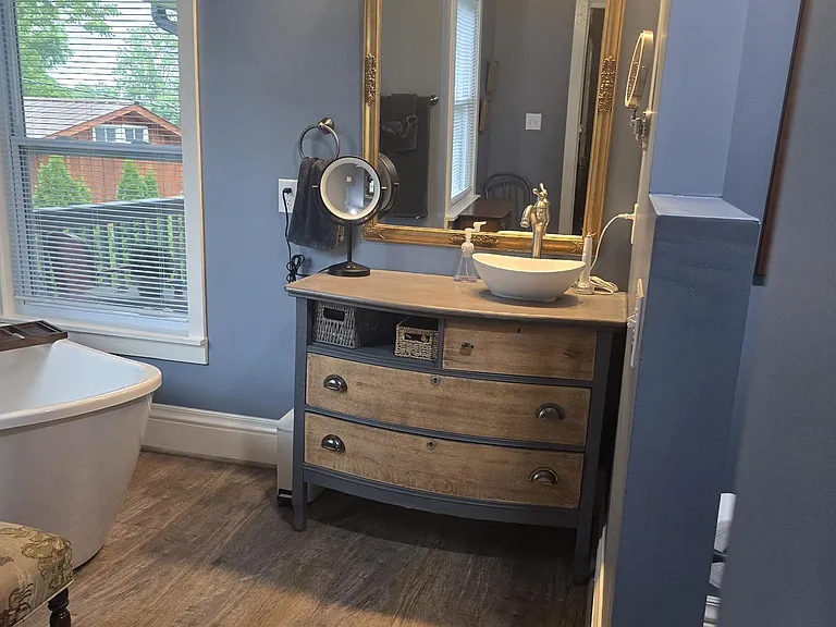 Master vanity with makeup mirror. Soaking tub area to the left.