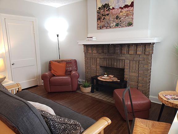 Living room mantle, super comfortable chair and ottoman, and coat closet.