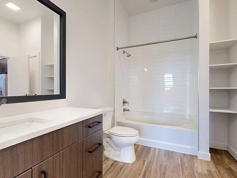 Apartment Bathroom with large soaking tub and Plank Flooring.