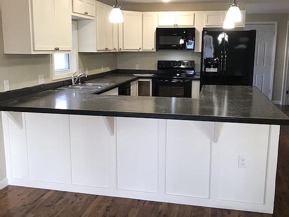 Open kitchen with a bar flows into the spacious living room.