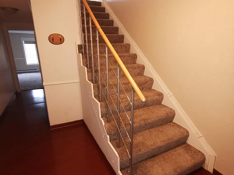 Hall way from front entrance and stairs up to upstairs and living room.
