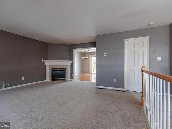 Bright living room with gas fireplace opening into dining area.