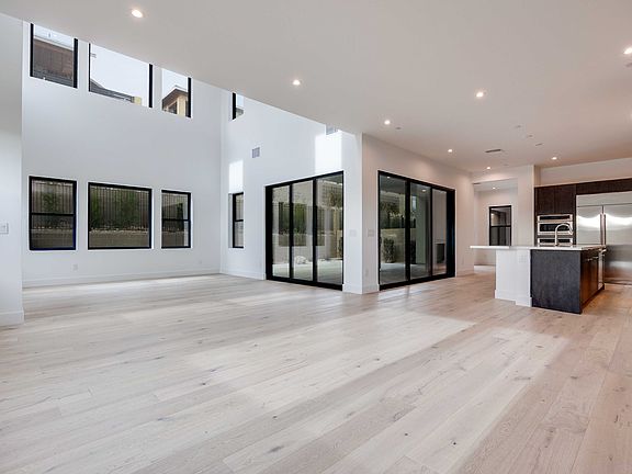 A spacious, modern interior with large windows, hardwood floors, and a minimalist design aesthetic.