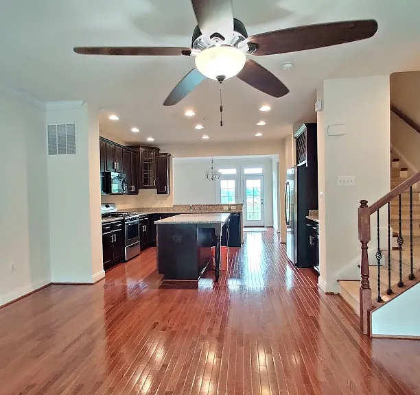 Comfortable living area with kitchen and dining area at the background leading to outdoor deck on 2nd floor