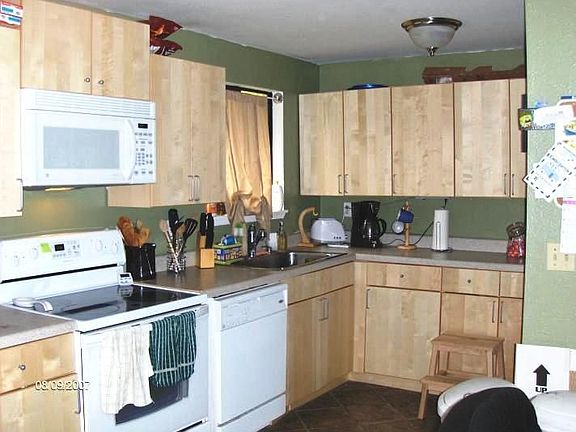 Kitchen has new counters, cupboards, floor, and appliances