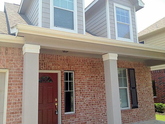 Great brick siding and lovely colums help you welcome visitors to your front door.