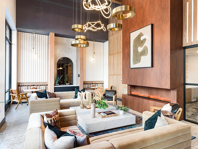 A thoughtfully layered lounge at Modera Higley Commons, where warm materials, sculptural lighting, and inviting seating set the tone for relaxed gatherings.