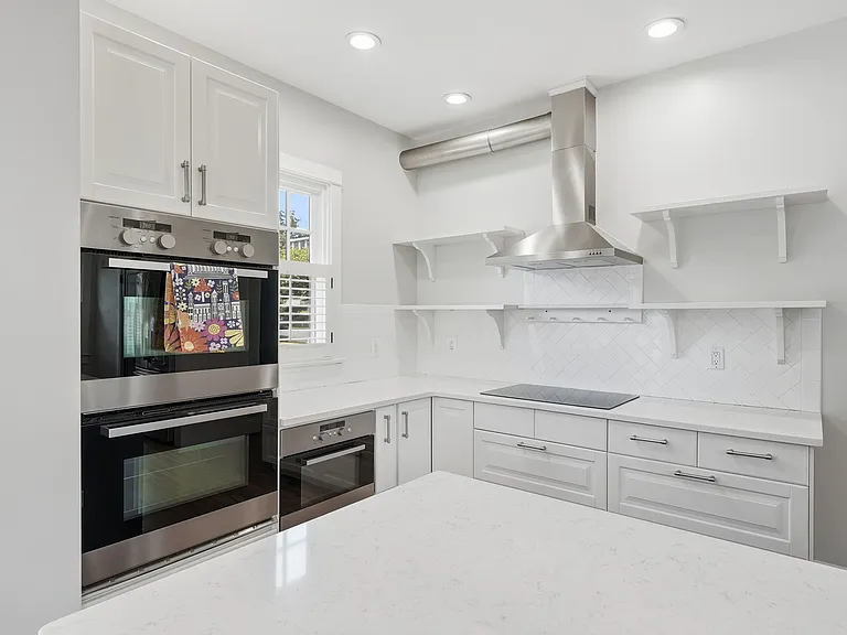 Renovated chef's kitchen with oversized island and stainless steel appliances