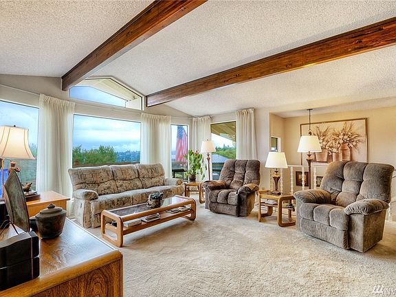 The formal living room features vaulted ceilings with beams and a gas fireplace.