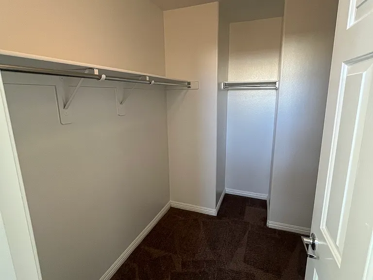 Primary bedroom walk in closet