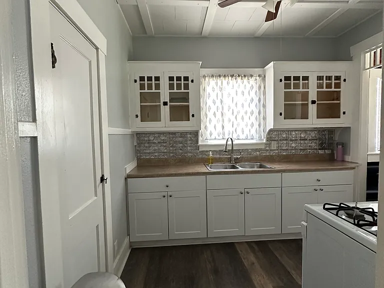 Charming kitchen with original glass cabinets and vaulted effect ceiling. Gas stove, refrigerator included.