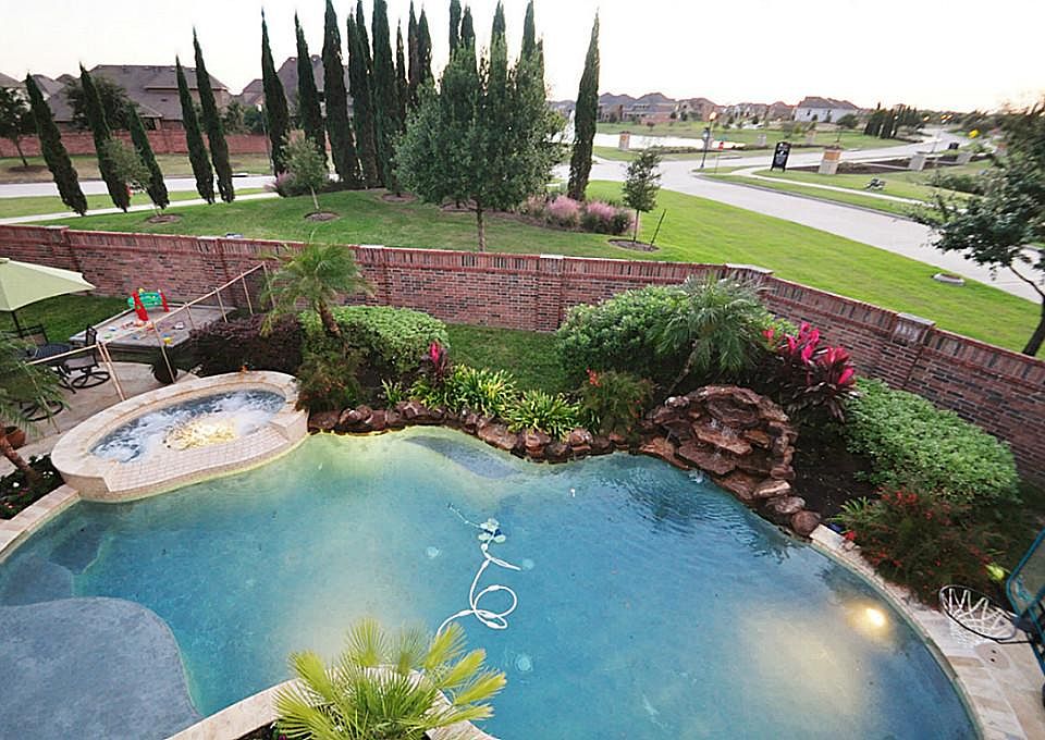 Enjoy the views of TWO stocked lakes, from your second story over-sized balcony*Brick fence surrounds the property providing security & privacy