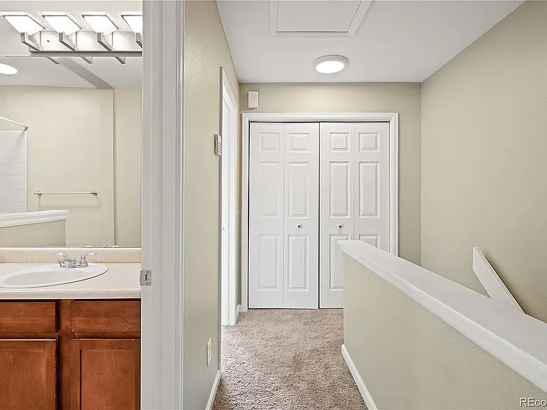 Upstairs hallway looking at linen closet, full bathroom and bedroom entrance.