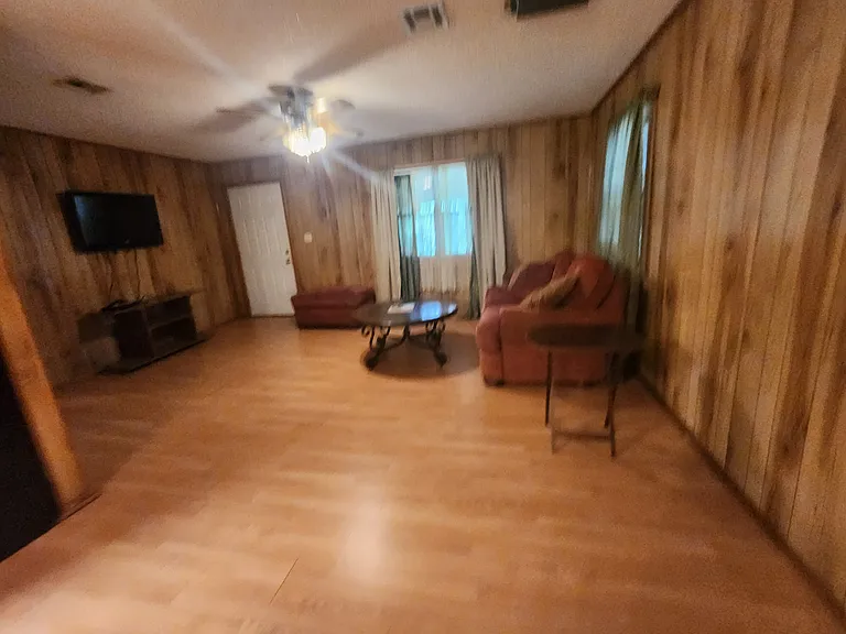 Living room, partially furnished. Back to door to large covered porch.