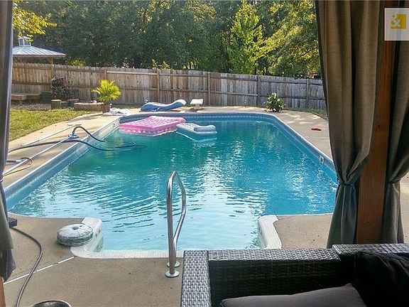 18x37 in-ground, saltwater swimming pool with diving board. The shallow end is 4' and the deep end is 9'. There's a fire pit in the far corner of the yard.  Photo from summer of 2018.